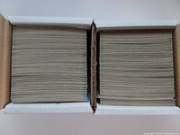 Two white boxes tightly packed with hockey cards shown from the top, revealing the sides of the cards inside.