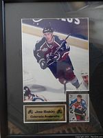 Framed Joe Sakic photo with hockey card and name plaque, showing details of the photo and card