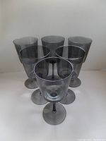Front view showing six smoky grey wine glasses arranged in a triangle.