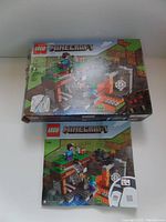 Photo showing two LEGO Minecraft set boxes featuring a Minecraft scene with figures including Steve and a spider.