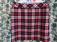 Front view of the plaid skirt laid flat showing entire garment and plaid pattern with red, navy, and white colors.