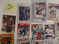 Photo of rookie hockey cards from the 1990s in protective sleeves showing Joe Sakic, Mats Sundin, Curtis Joseph, and others.