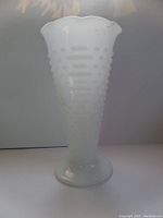 Full view of the white milk glass trumpet vase showing hobnail textured pattern and scalloped edge top.
