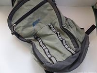 Front view of vintage MEC backpack showing zippered compartments, strap loops, and elastic side pocket