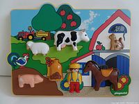 Photo showing entire farm puzzle with seven colorful 3D puzzle pieces (cow, pig, sheep, rooster, squirrel, farmer figure, horse) placed on the puzzle base depicting a farm scene with apple tree, barn, and tractor.