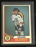 Front of 1974-75 O-Pee-Chee Phil Esposito Boston Bruins hockey trading card showing player image and Bruins logo.