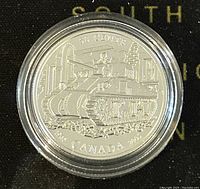 Obverse side of the silver coin showing tank design and inscriptions.