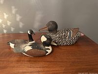 Front and side view of the three duck figurines showing size variation and detailed hand-painted feather patterns.