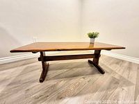 Full front view of rectangular trestle coffee table with plant prop