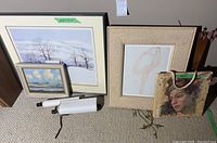 Large framed print of winter landscape with snow-covered trees (26.25 x 22.25 inches) alongside smaller prints and an art tote bag