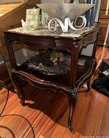 Full side angle showing the wooden carved legs, two-tier design, and overall structure of the vintage hall table with marble top.