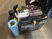 Overview of all items showing Eliminator PowerBox box, battery charger box, several spray bottles, and blue paper towel roll