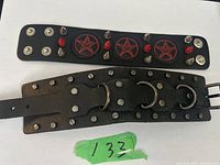 Two black leather goth bracelets. One with pentagram symbols and studs, the other with metal rings and studs.