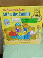 Front cover of The Berenstain Bears All in the Family book showing the family bears reading together on a couch, with bright yellow background.