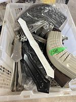 Photo of assorted mechanical or structural parts in different shapes and colors inside a white plastic basket.