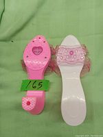 Top view of the pair of pink transparent plastic girls' play shoes showing heart decorations on the sole and strap. Includes size tag (165).