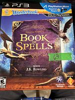 Front cover of sealed PlayStation 3 Wonderbook: Book of Spells game, showing title and required PlayStation Move hardware.