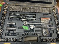 Top view of the entire ratchet tool set inside a black plastic carrying case, showing ratchet handles, sockets, adapters, and accessories arranged in molded slots.