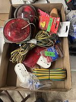 Box containing various used and new trailer wiring parts, red round lights, wiring harnesses and connectors.