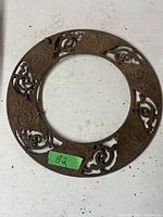 Top view of the round stove pipe grill showing ornate scrollwork cut-outs and signs of rust.
