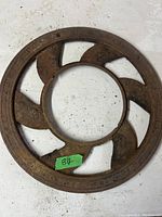 Top view of first vintage stove pipe grill, showing round cast iron with spiral openings and rust.