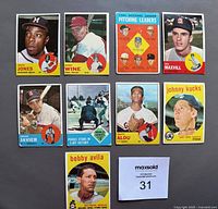 Front view of 9 Topps baseball cards laid out flat on dark grey surface. Cards include players Mack Jones, Bobby Wine, Don Drysdale pitching leaders card, Don Maxvill, Julian Javier, World Series pitching scene, Walt Alou, Johnny Kucks, and Bobby Avila.