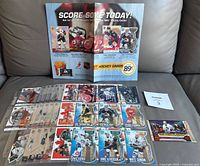 Full lot including binder pages with hockey cards spread out, promotion menu, unopened wax pack on black background with maxsold number card.