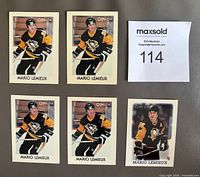 Front view of five mini hockey cards featuring Mario Lemieux in Pittsburgh Penguins uniform, four cards have same image from 1987-88 and one different from 1988-89