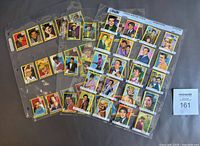 Top view of multiple sheets containing the Vlinder cards with portraits of various celebrities in color borders.