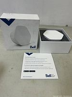 Bell Capsule Wi-Fi 6E router device in original opened box with installation instructions card