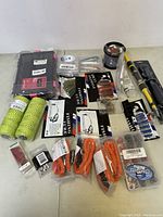 Fishing accessories lot arranged showing fishing line, rods, lures, ropes, tackle box and other items.