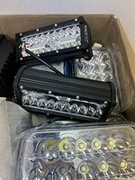 Box containing NAOEVO black LED light bars with visible LED bulbs and reflective panels