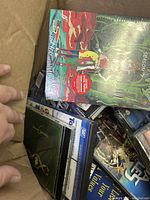 Box filled with various DVDs and CDs, showing titles including Rick and Morty Season 7 on top.