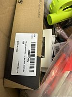 Close-up showing brown cardboard box labeled 100x200mm shower base with waste, made in China.