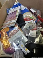 Overhead view of miscellaneous box contents showing various packaged items, tools, and hardware.