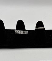 Front view of both rings displayed on black velour ring stand