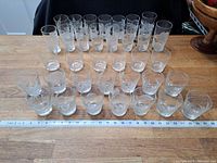Wide shot showing all the glasses, arranged in rows with measuring tape in front for scale.