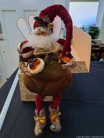 Front view of the Mark Roberts Glazed Pear Fairy collectible showing full figure, detailed face and costume, including wings, hat, and pears in hands, with original box in background.