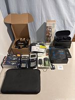 Full lot overview including smart glasses, calculators, remotes, glasses, and multimeter.