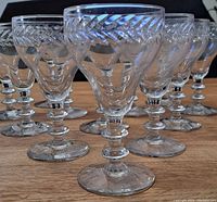 Cocktail and cordial glasses grouped together, showing clear crystal with etched diagonal pattern around upper bowl and ornate segmented stems and bases.