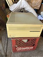 Side view of the vintage Apple Macintosh IIci computer unit on a crate, showing beige color and horizontal vents