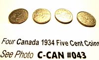 Four Canadian 1934 five cent coins showing reverse sides with denomination and beaver design, arranged in a row on paper with lot label.