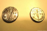 Two 1944 Canada Victory five cent coins showing reverse side details with '1944', large V, torch and maple leaves.