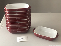 Ten red ceramic rectangular baking dishes stacked with one dish set next to stack, showing the Lagostina logo on the side.