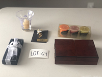 All items in the lot displayed on a light surface, including cards in wooden holder, candles, candle holder, wine stopper, and angel pin