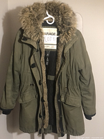 Front view of the camo green cotton winter coat with detachable faux fur lining showing coat style, pockets, and closure.