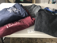 Six men's sweaters and sweatshirts from Guess, American Eagle, and H&M laid out on a table.