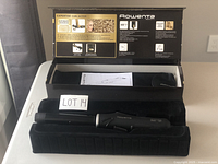 Photo of the curling iron inside its original box showing brand, model, and key features like automatic rotation and ceramic coating.