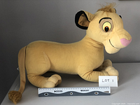 Side view of the vintage Baby Simba plush showing its length and facial features with a measuring ruler.