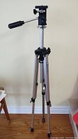 Full view of the Heiwa HS-518 tripod showing aluminum legs, leg locks, extendable center column and head with handle.